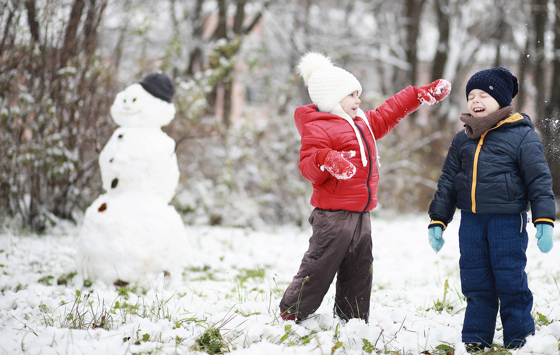 Två barn som har snöbollskrig.