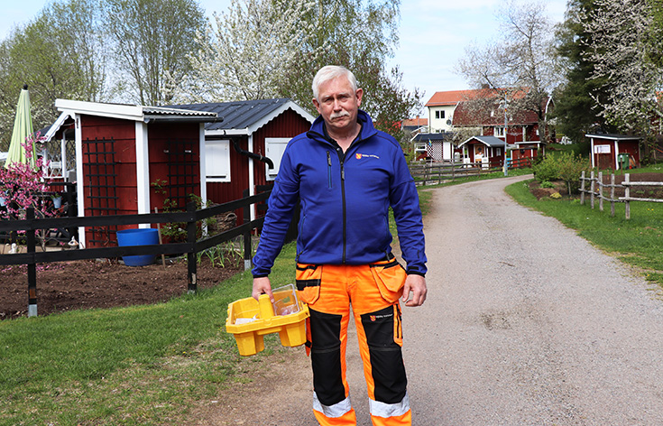 Man i arbetskläder som håller i en verktygslåda.
