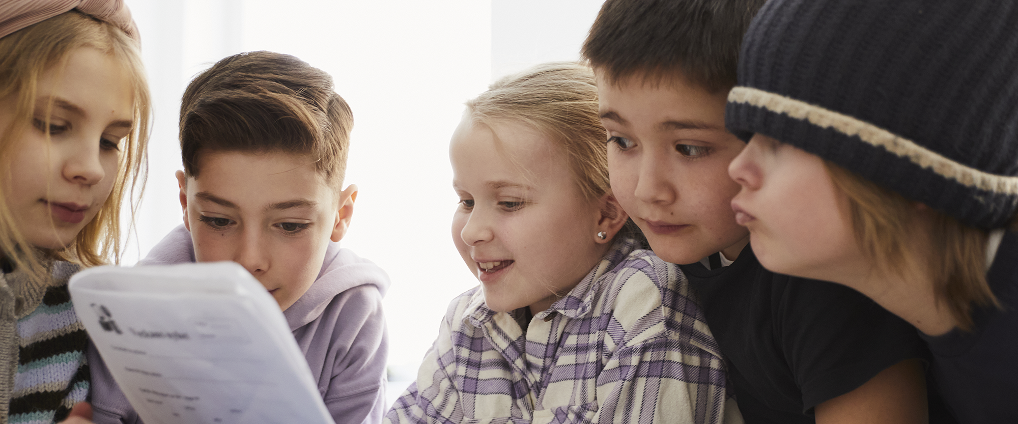 Fem elever har grupparbete i klassrummet.