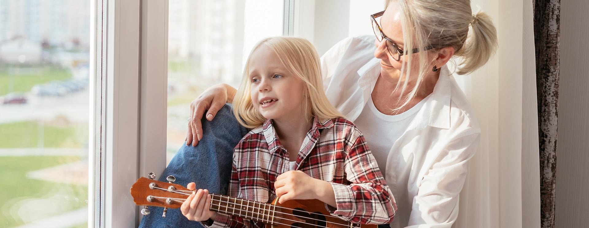 Mamma med barn som spelar ukulele