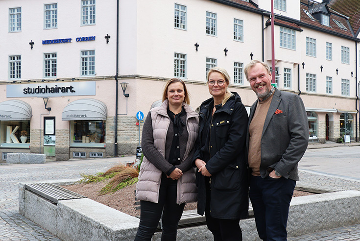 Två kvinnor och en man står vid en gata i Mjölby centrum.