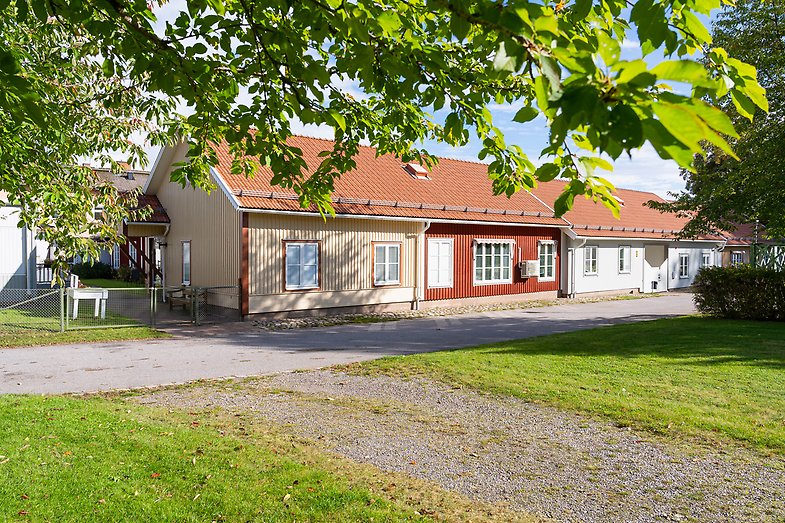 Framsidan av fastigheten Sankta Ingrids. Trähus i beige, rött och vitt.