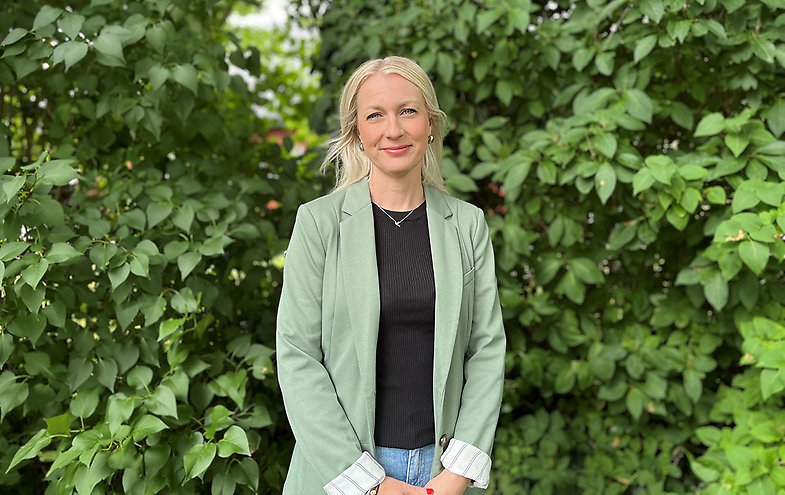 Elin Forsman står framför en syrénbuske.
