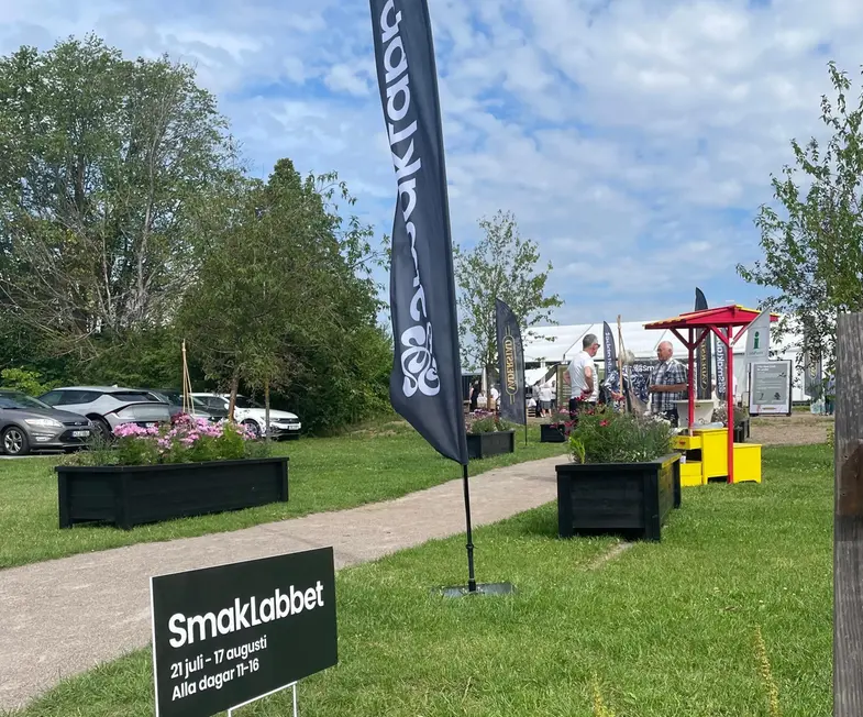 Grusgång upp till eventhallen med flaggan i förgrunden. 