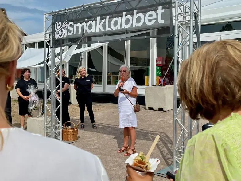 Invigningstalare står vid ingången till Smaklabbet.