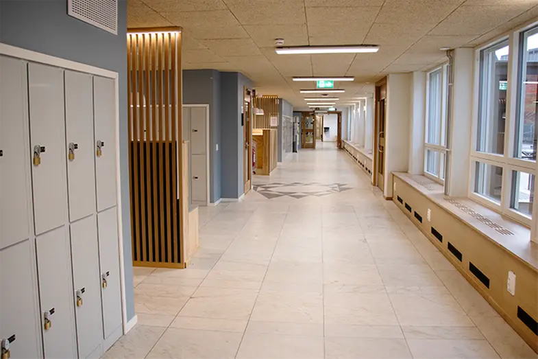Skolkorridor med blå väggar. 