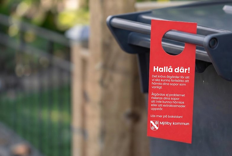 Röd lapp hänger på sopkärl