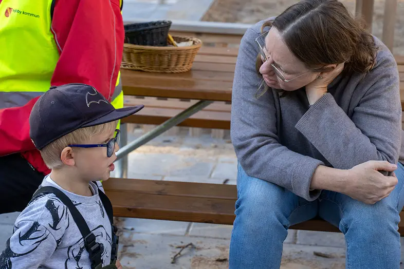 Barn pratar med vuxen. 