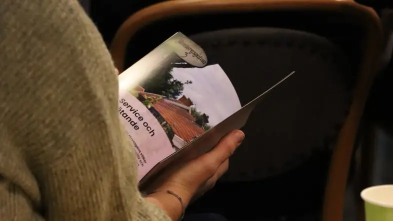 Närbild när en person bläddrar i broschyren.